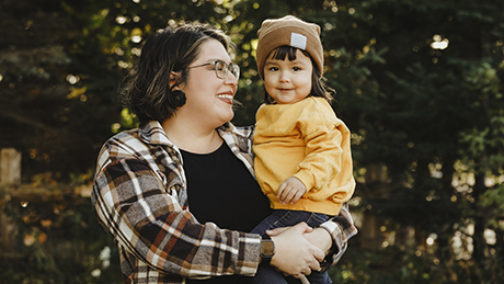 Image shows Indigenous toddler girl in the arms of her mother